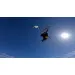 Advanced kitesurf jump under a clear blue sky during a clinic with IKO instructor